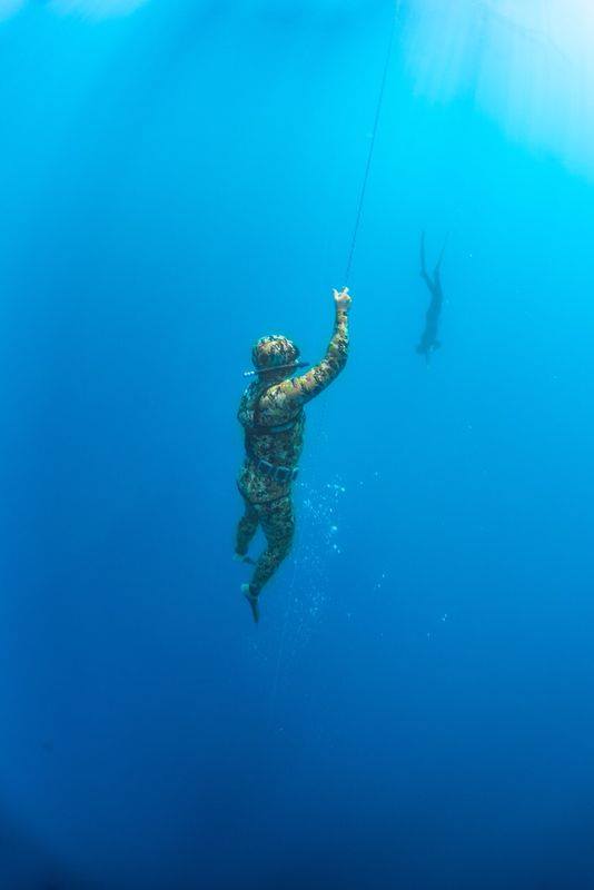 Buzo ascendiendo por la línea hacia la superficie en aguas profundas